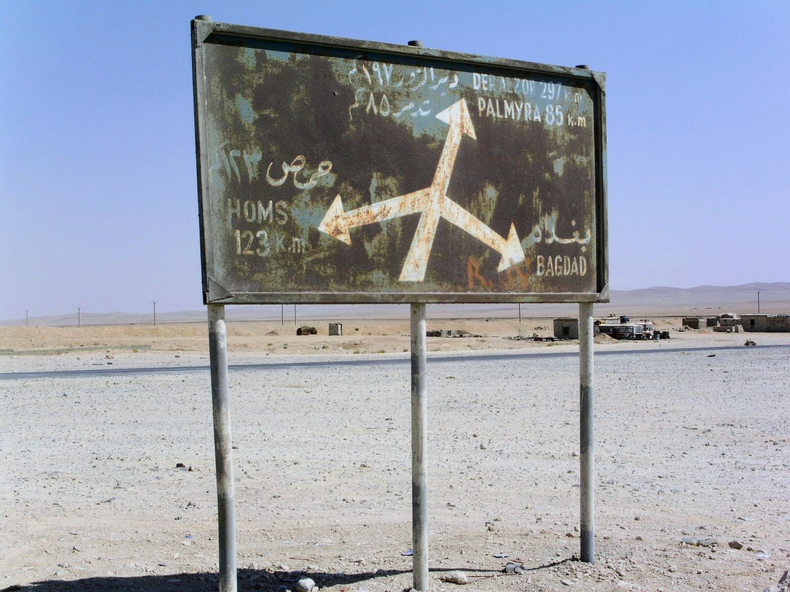 Verrosteter Wegweiser in der syrischen Wüste mit Richtungen nach Palmyra, Homs, Deir ez-Zor und Bagdad