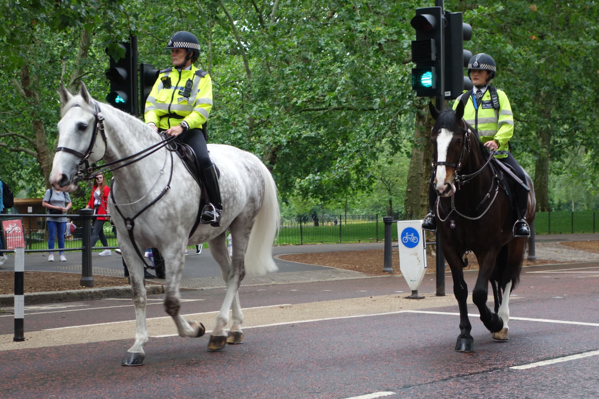 Zwei berittene Polizistinnen der Metropolitan Police reiten am Rand des Hyde Park über die Strasse
