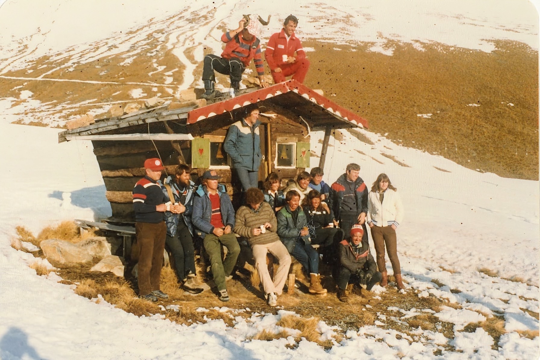 Gruppe von Mitarbeitenden vor einer kleinen Hütte im Skigebiet