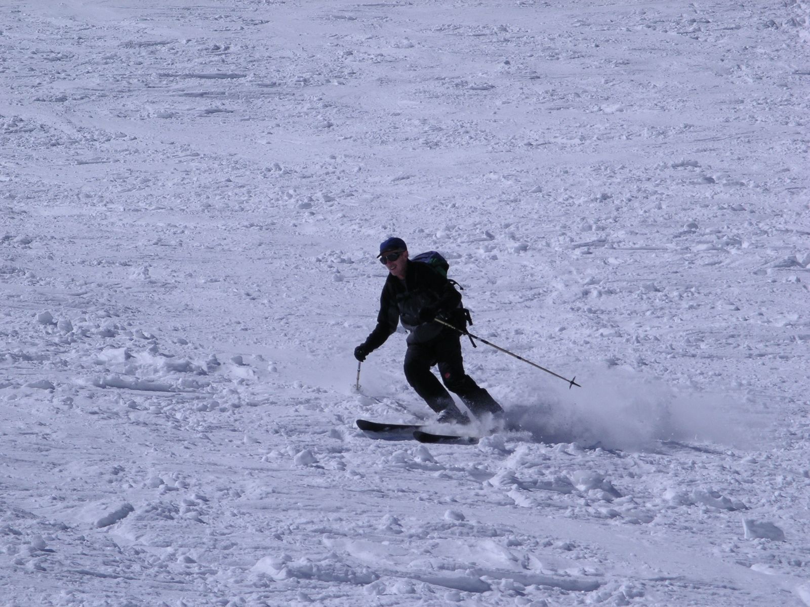Skifahrer zieht einen Schwung in den frühlingshaften Sulzschnee
