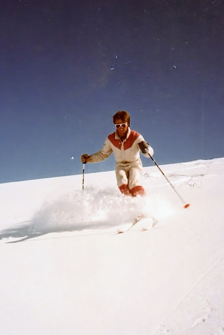 Skifahrer im Tiefschnee vor tiefblauem Himmel
