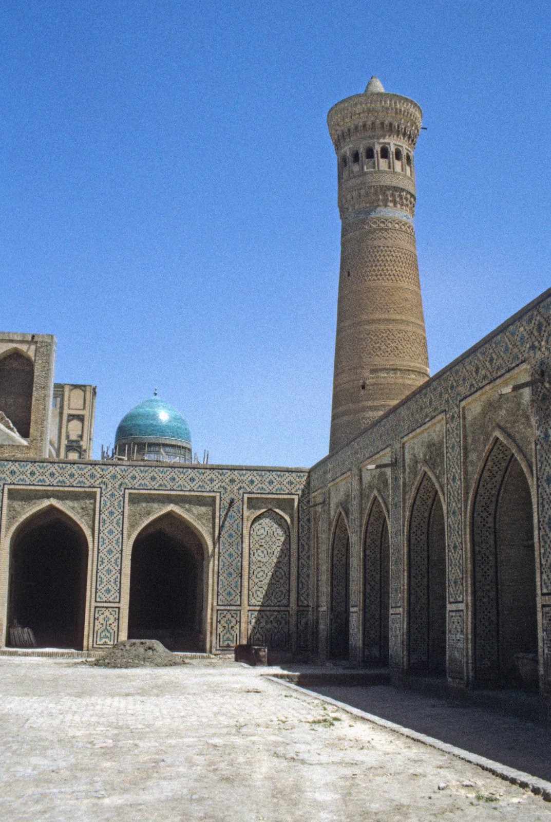 Innenhof einer Moschee mit hohem Backsteinminarett