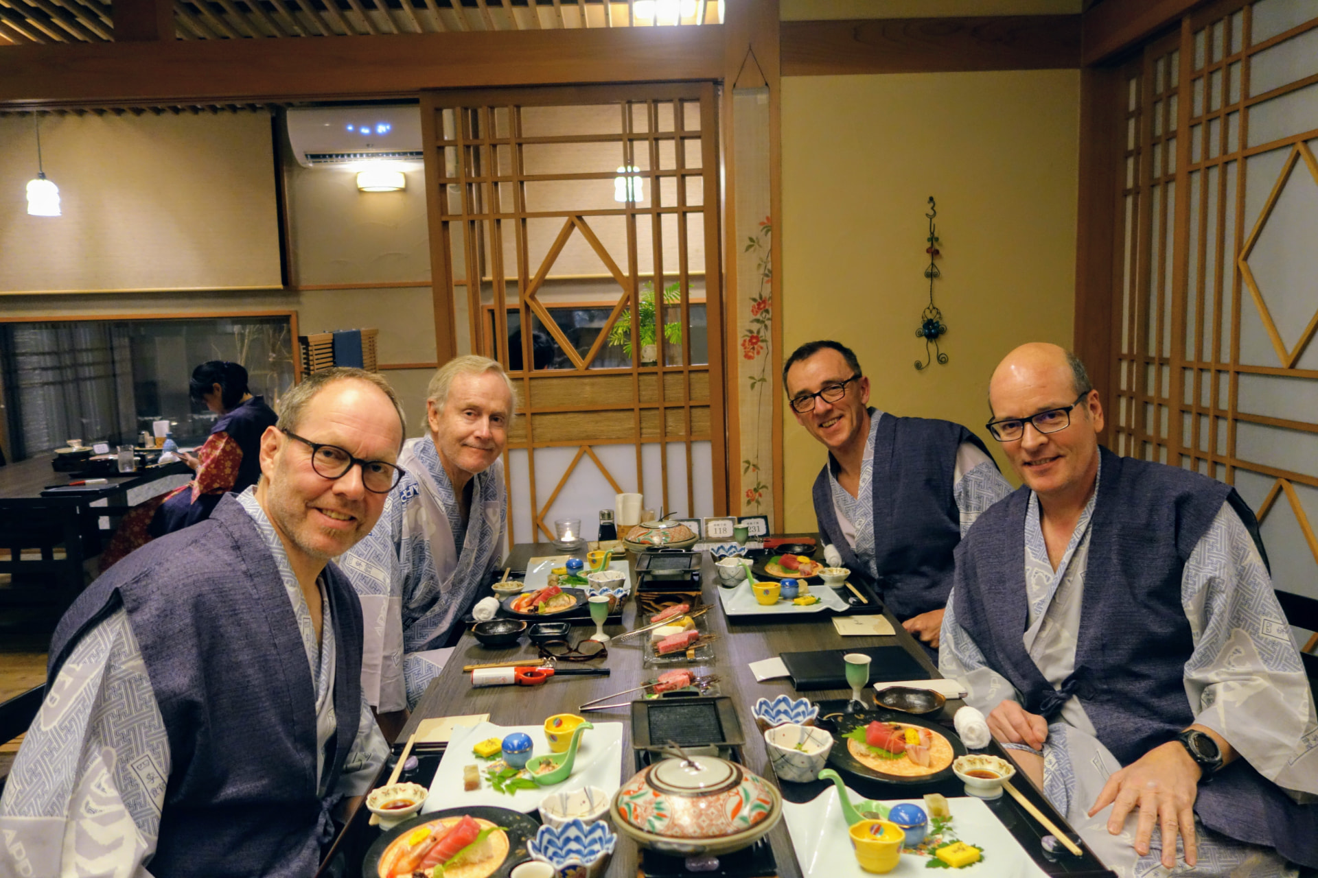 Vier Männer in Yukatas beim Abendessen im Ryokan