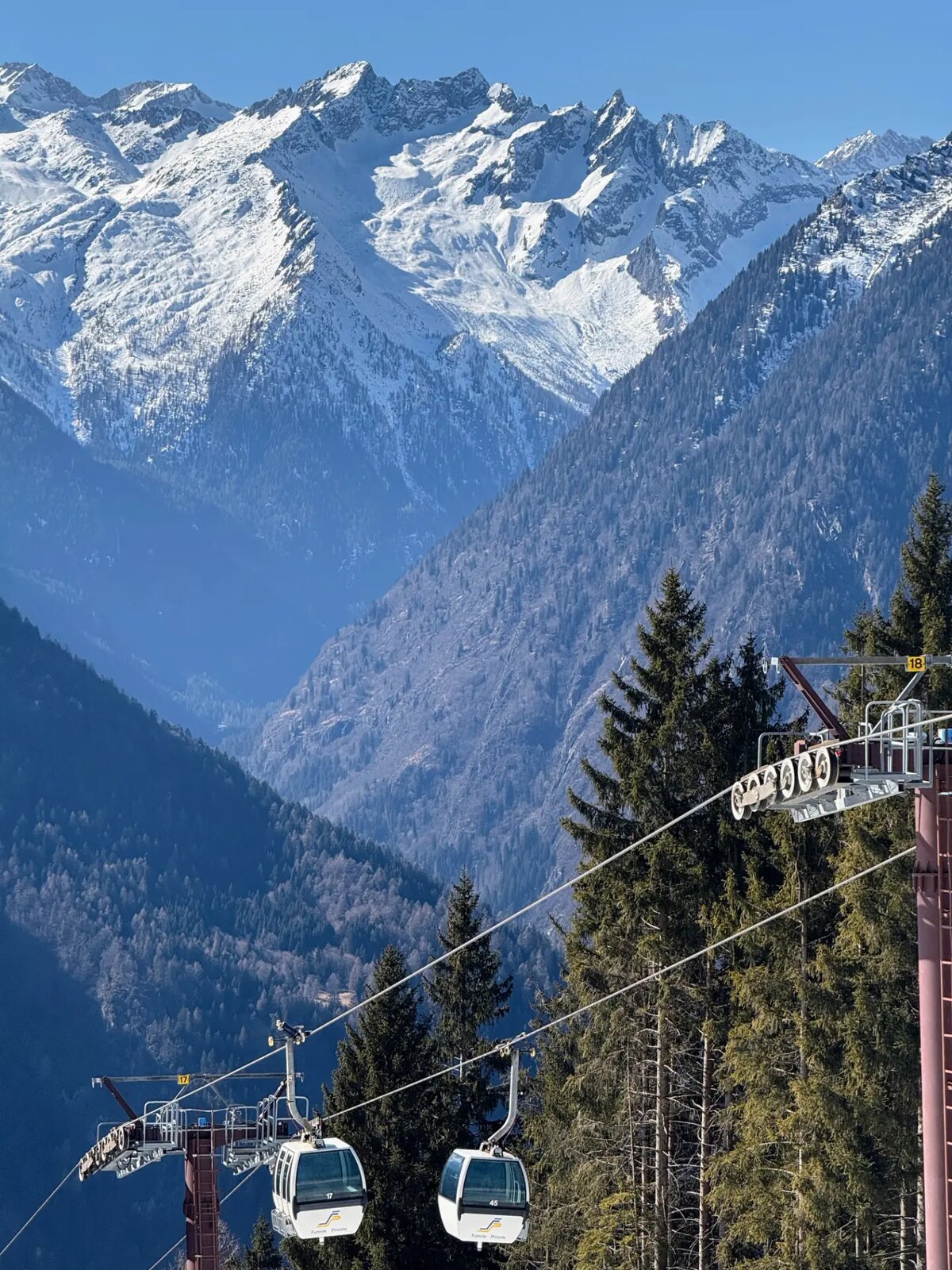 Gondelbahn Pinzolo vor verschneiter Bergkette