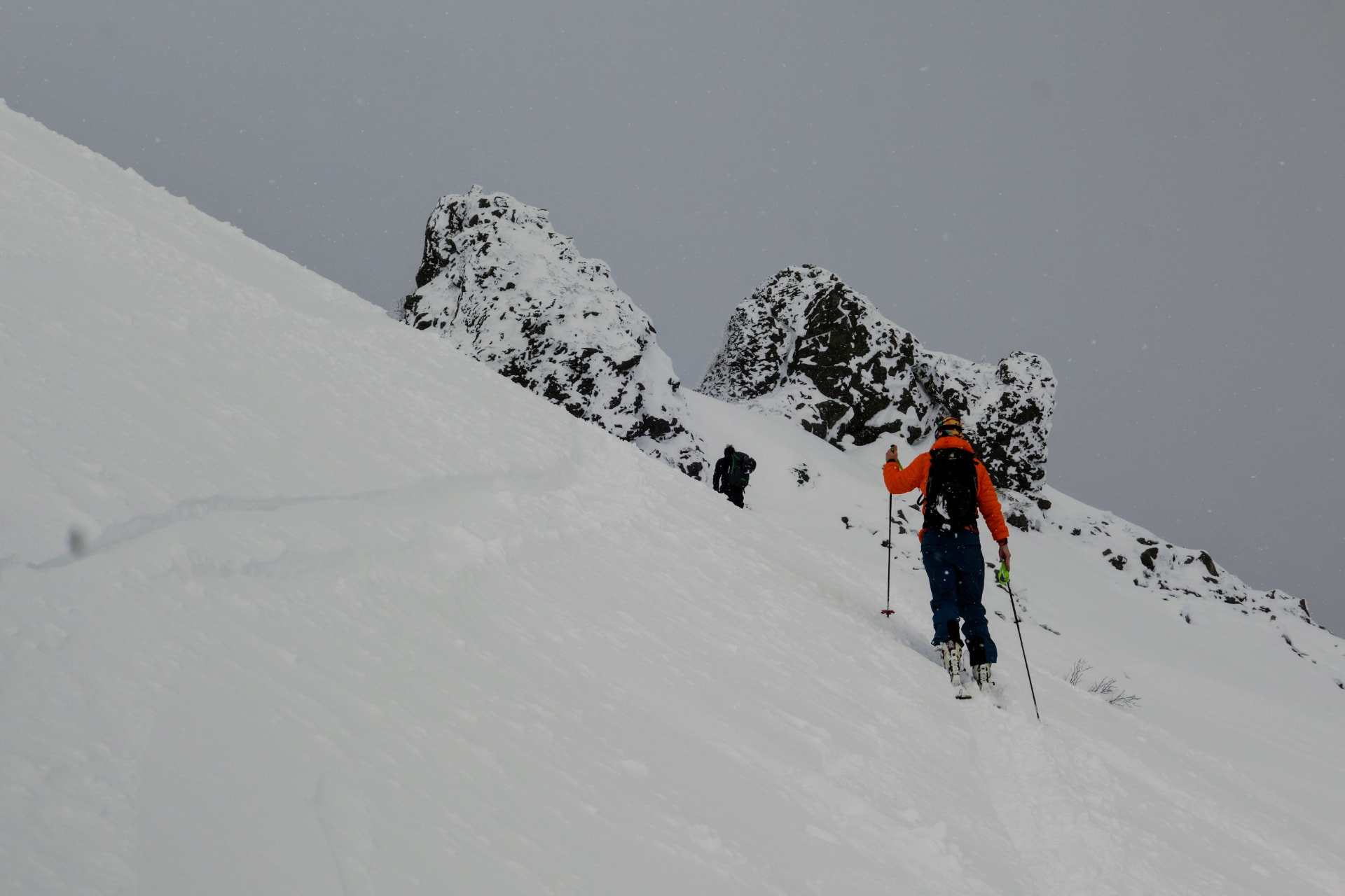 Skitourengeher im Aufstieg zu verschneiten Felstürmen