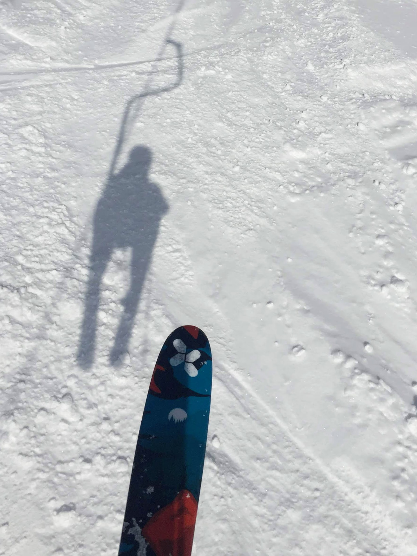 Schatten eines Skifahrers am Schlepplift im Schnee